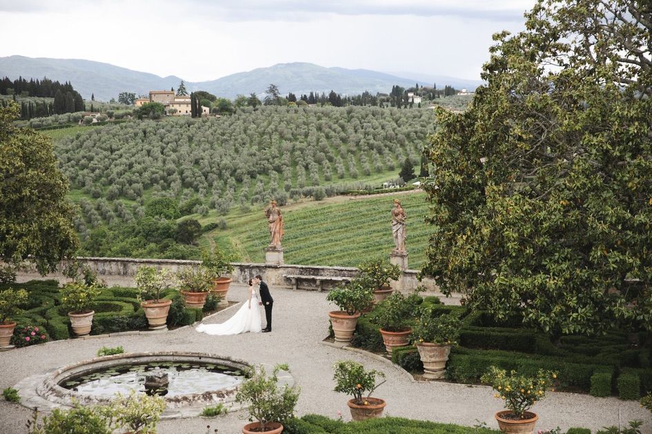 Bride and groom kiss in the garden at wedding villa in Florence with view