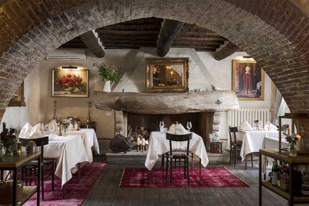 Cosy dinner tables with fireplace at Chianti wedding hamlet
