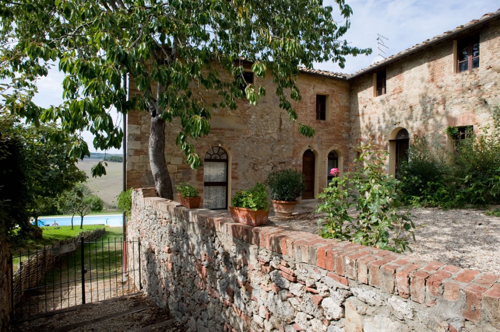 courtyard of the romantic farmhouse with pool and countryside view of tuscany