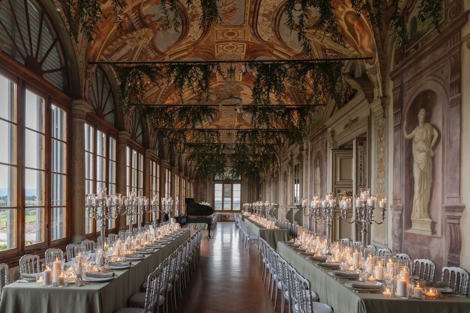 Dinner tables in the gallery at wedding villa in Florence with view