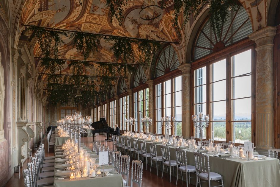 Gallery with dinner tables and piano at wedding villa in Florence with view