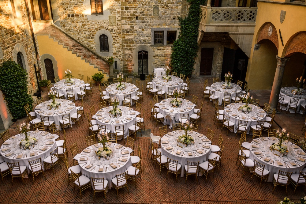 wedding dinner in a courtyard of a medieval castle in chianti tuscany