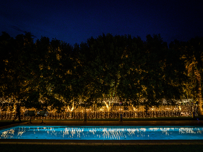 Night view of the pool with lights at charming Farm Resort in Maremma