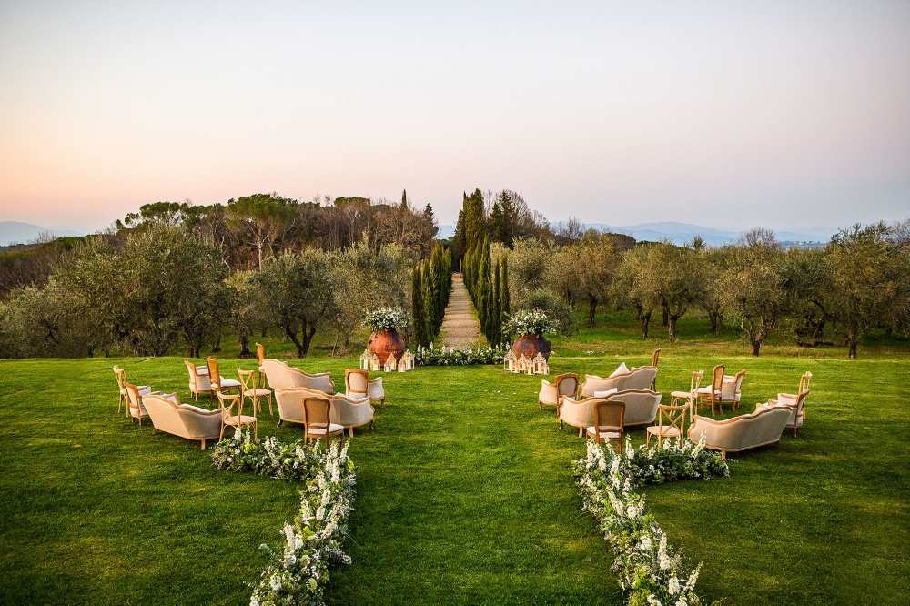 outdoor ceremony in tuscany with flowers and sofas