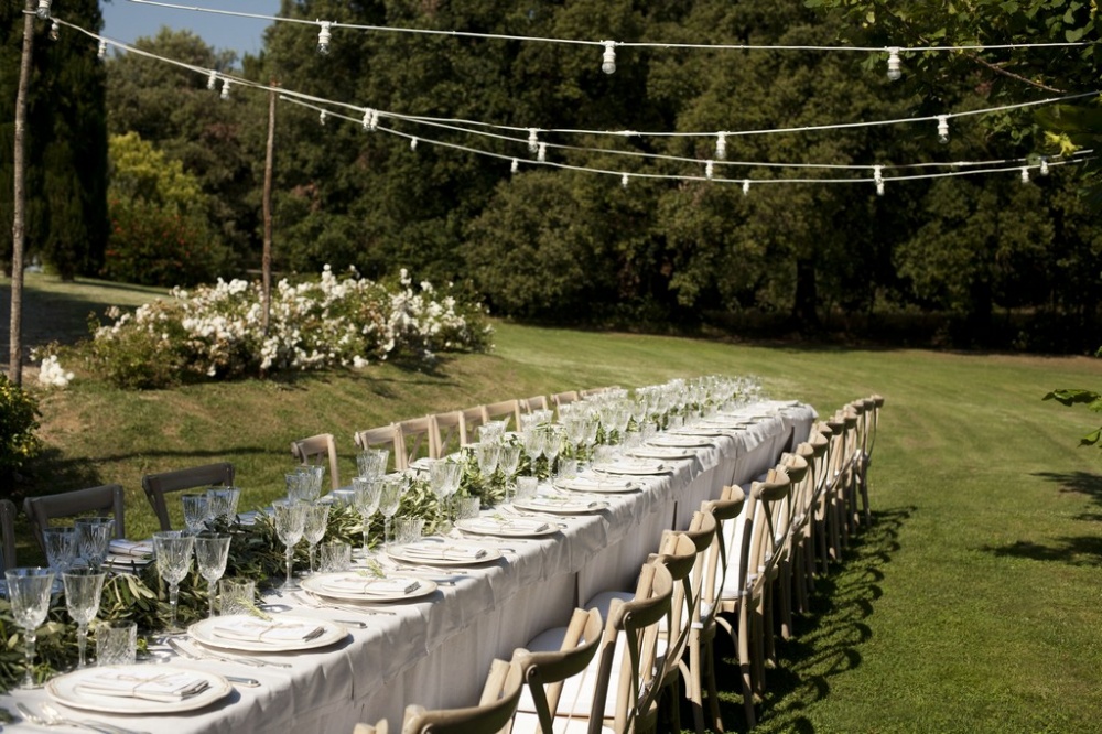 rectangular wedding dinner table with- vintage lights in a romatic weddin villa in siena