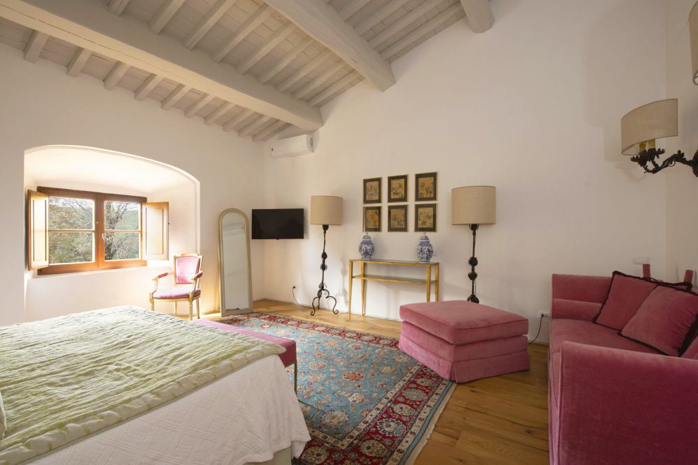 View of the white and pink bedroom of the Medieval castle in Tuscany