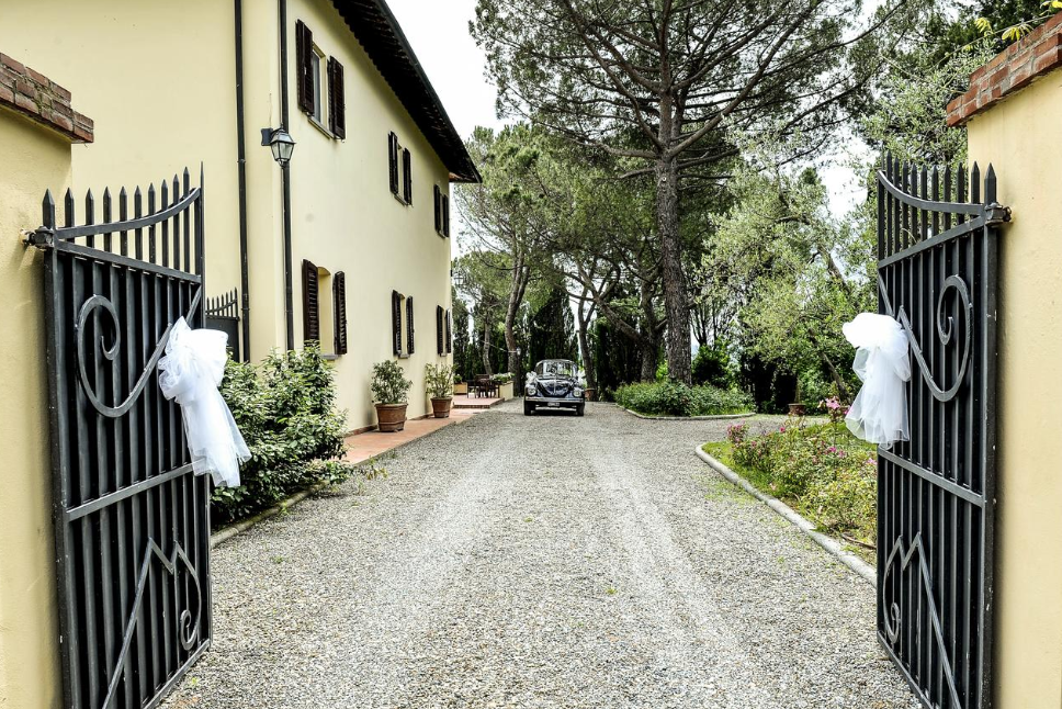 vintage car entering in the gate of a villa for weddings on the tuscan hills