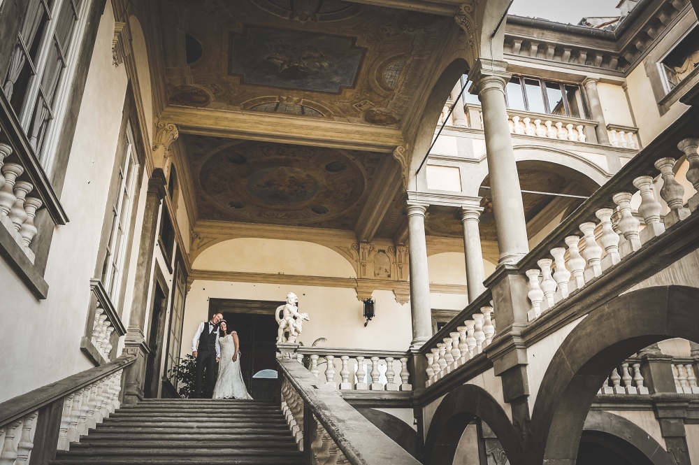 real couple on stairs in a palace for wedding in lucca