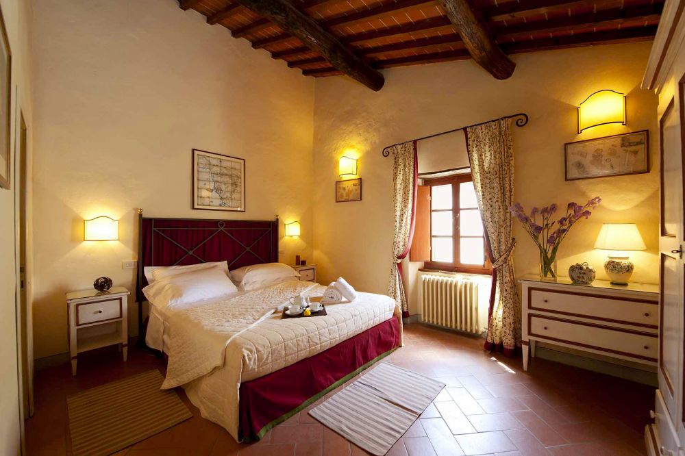 Yellow, red and brown bedroom at the farmhouse for weddings in Tuscany